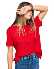 Fototapeta premium Teenager caucasian girl wearing casual red t shirt covering eyes with arm, looking serious and sad. sightless, hiding and rejection concept