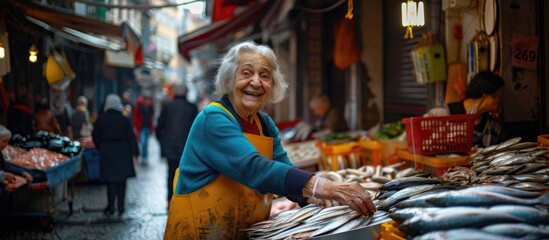 Obraz premium Joyful Vendor: Elderly Lady Selling an Assortment of Fresh Sardines at the Bustling Bolhão Fish Market in Porto - A Snapshot of Tradition and Happiness.