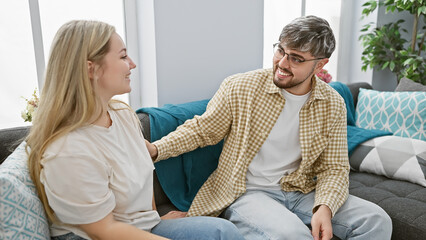 A cheerful couple lounges in a cozy living room, embodying love and a harmonious relationship in a...
