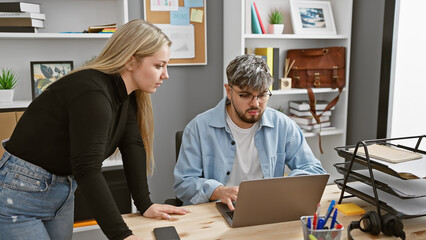 A man and woman collaborate in a modern office, showcasing teamwork and professionalism amidst technology and office supplies.