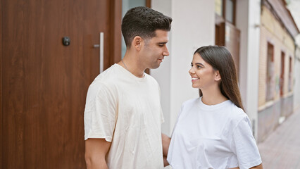 A loving couple enjoying a moment together on a quiet urban street, highlighting their casual style and affectionate relationship.