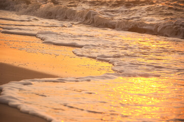 Sea wave with foam on the sand. Summer sea background