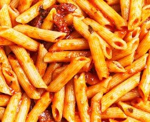 Close-up of penne pasta in tomato sauce garnished with herbs