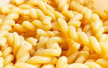 Close-up of cooked fusilli pasta with a glossy surface, ideal for culinary themes and recipe visuals.