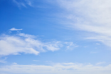 Obraz premium Vivid blue sky with fluffy white clouds spread thinly across the expansive serene backdrop, ideal for backgrounds or nature themes.