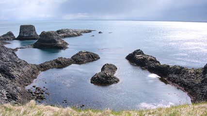 Panoramic view across the basalt cliffs with seagulls and rocks near Arnarstapi, Iceland