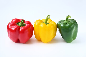 three colorful sweet bell peppers on a white background close-up