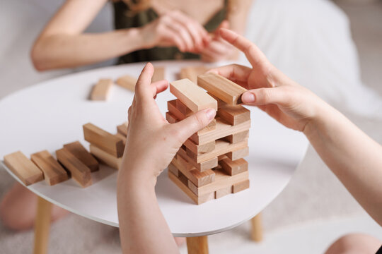 two women playing Jenga board game at home, excitement and relaxation, mind development concept, - Powered by Adobe