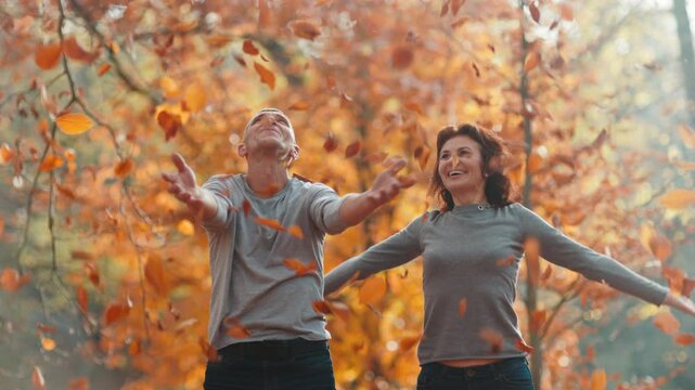 Hello autumn. happy romantic boyfriend and girlfriend in the park throwing autumn leafs.