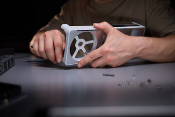 A technician is skillfully repairing a computer GPU fan with precision tools in a workshop