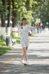 girl rejoices and spins in a dress on the street