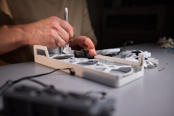 A technician is skillfully repairing a computer GPU fan with precision tools in a workshop