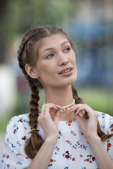 Attractive young caucasian woman is enjoying warm sunny weather walking outside. Brown-haired. Relaxation concept