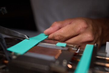 Technician assembling a GPU, focusing on installing computer hardware components