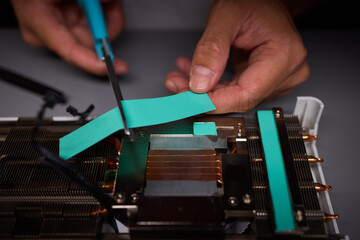 Technician assembling a GPU, focusing on installing computer hardware components