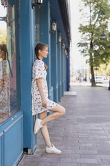 Girl stands leaning against the wall