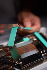 Technician assembling a GPU, focusing on installing computer hardware components