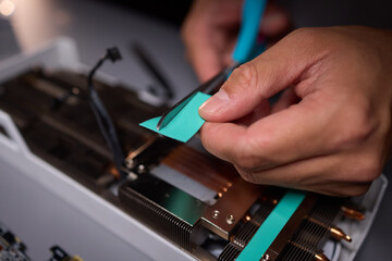 Technician assembling a GPU, focusing on installing computer hardware components