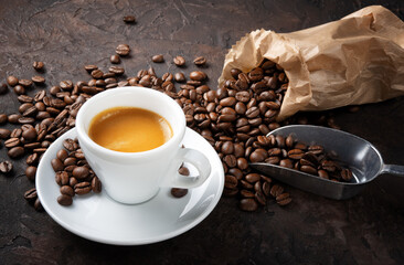 Espresso and coffee beans on brown roughcast background.
