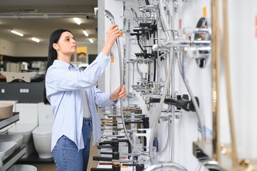 Woman choosing a shower head in a hardware store