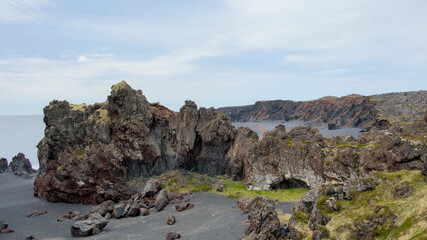 Icelandic seacape with volcanic rock formations and lava fields in summer near Dritvik, Snaefellsnes peninsula