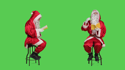 Santa claus character reads fiction sitting on chair, using book for knowledge and education. Young man portraying wise father christmas reading literature or poetry, novel story.