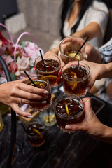 Friends celebrating at a lively party, toasting with cocktails, enjoying and having fun