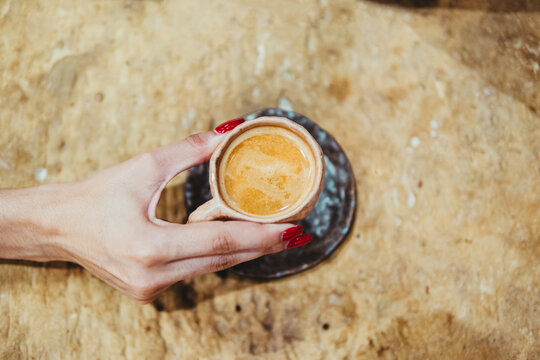 Close-up of female hand holding espresso cup