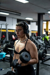 Vertical shot of a Caucasian young woman doing workout in the gym. Fitness, wellness exercise concept