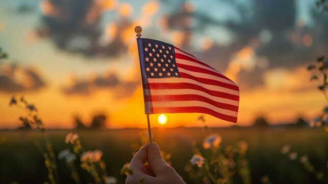 American flag sunset image. Capture the essence of American pride with this beautiful image of an American flag waving in the golden hues of sunset.