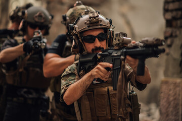 Fototapeta premium Portrait of soldier in crowd with rifle going in action at warzone.