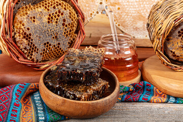 Magical honeycomb close up, Honey harvesting, honey picking. Organic honeycomb (Turkish Karakovan Honey). Organic honeycomb in jar with honey dipper on vintage wooden background.