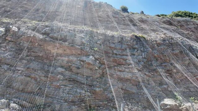 Crete Greece Europe.  03.07. 2024.  Heavy duty rockfall netting to prevent and control rock fall on a mountainside in Crete.