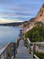 Obraz premium Treppe zur Bucht mit Blick auf das Meer bei Sonnenuntergang auf Mallorca