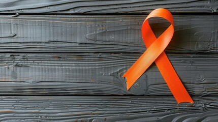 Grey table with orange ribbon top view for multiple sclerosis awareness