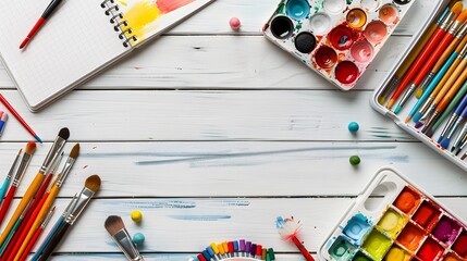 Creative work desk for self-expression, paint brushes, paintbox with watercolors, crayons, pencils and notebook paper on white wooden background, artistic workspace. Top view, flat lay, copy space. 