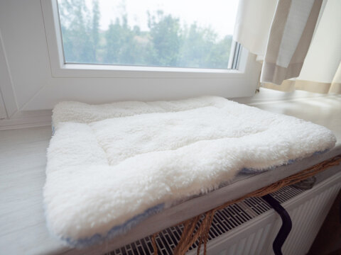 Pillow for a cat on a window sill, fluffy white, soft pet bed with fluff.
