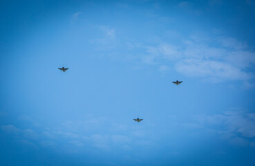 Three RAF typhoons flying, flying in formation back to their respected air fields after taking part in the kings fly past on a beautiful summers day with blue skies and slight cloud