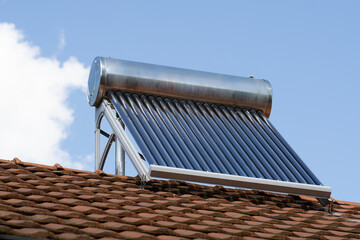solar water heater on a roof top, solar water heating panel, blue sky in the background