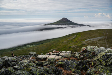 Städjan mountain peak rising above a sea of mist in Idre Dalarna, Sweden. The fog rolls over the hills and valley, creating a picturesque landscape