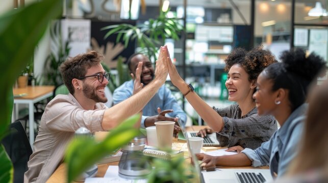 A group of diverse professionals celebrating a successful meeting in a modern office. AIG535