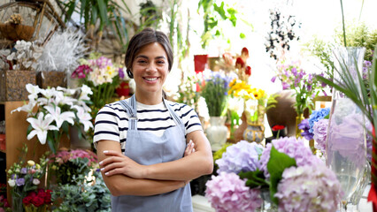 Portrait of a beautiful, young florist working at her store