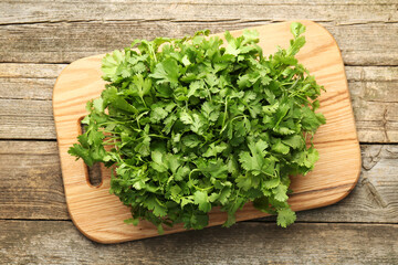 Fresh coriander on wooden table, top view