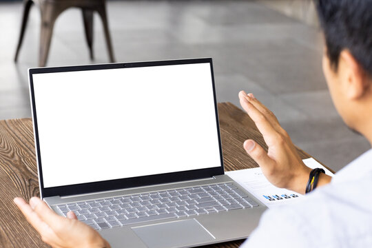 Using laptop with blank screen, man gesturing during video call at desk, copy space