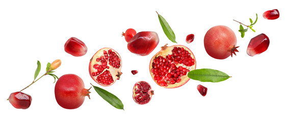 Fresh pomegranates, seeds and leaves in air on white background