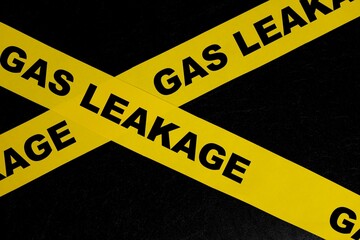 Gas leak or leakage caution danger and warning concept. Yellow barricade tape with word in dark black background.