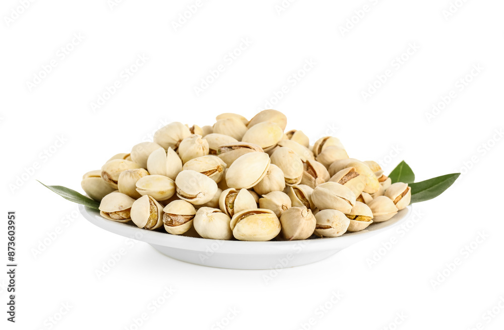 Poster Plate with tasty pistachio nuts and leaves on white background