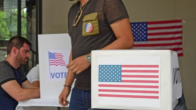diverse group of people voting in the us election, placing vote ballot in the polling box, vote in America. Concept of choice, democracy and freedom, multiethnic young citizens participating