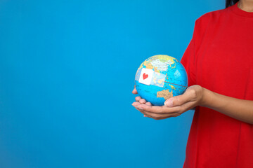 Woman Hands holding Globe With Red Heart Symbol On Plaster. Blood Transfusion, World Blood Donor Day, World Hemophilia Day Concept