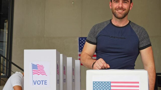 portrait of a smiling man voting in the us election, placing vote ballot in the polling box, vote in America. Concept of choice, democracy and freedom